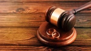 a pair of gold wedding rings, a judge's hammer